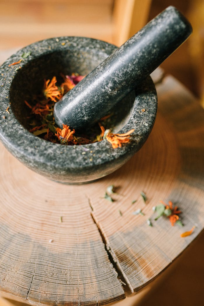Close-up of herbs in a granite mortar on a wooden board, perfect for herbal medicine concepts.